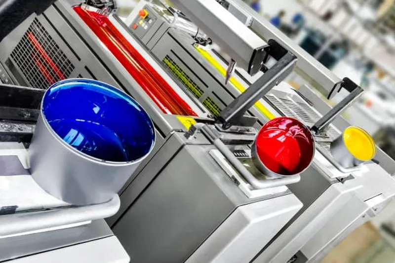 Bogenoffset-Druckmaschine mit Farbbehältern in einer Druckerei